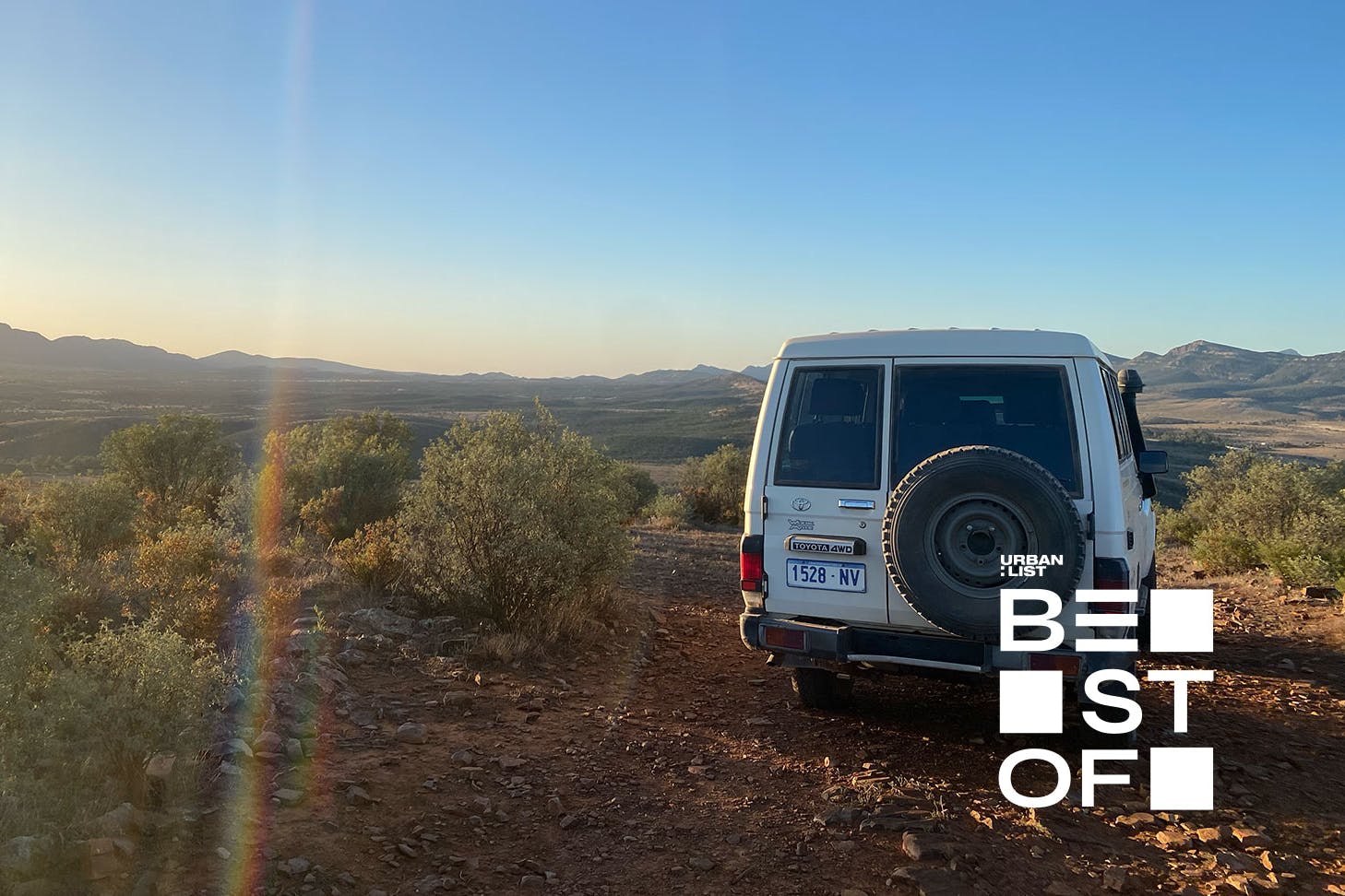 a troop carrier parked on a hill at sunset